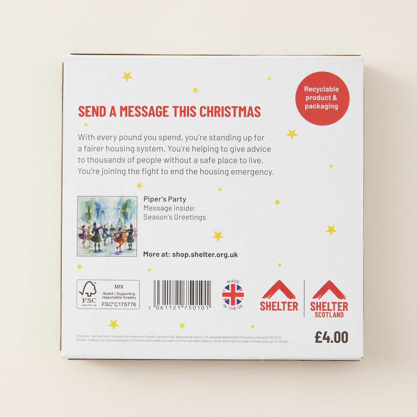 The back of a white cardboard box for a Christmas message service, featuring red and black text, a small illustration, and logos for Shelter and Birkwood Trust. The box is photographed on a light beige background.