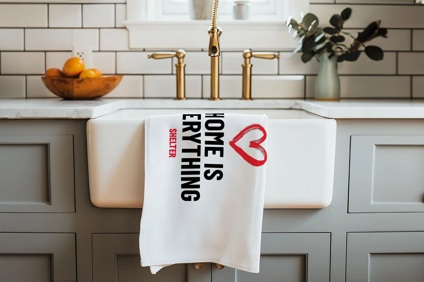 'Home is everything' teatowel folded up and hanging over a sink.