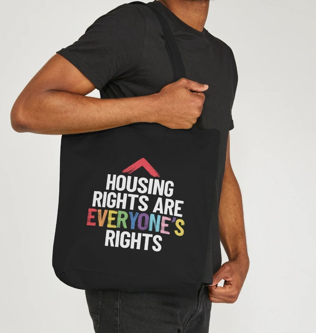 black tote bag with slogan "Housing rights are everyone's rights" The word everyone's is in the LGBTQ+ flag colours