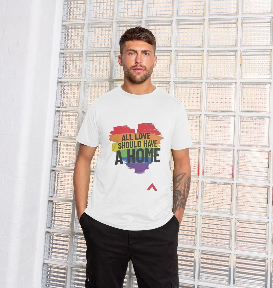 Male model wearing All love should have a home tshirt. Rainbow heart with bold black text "all love should have a home"