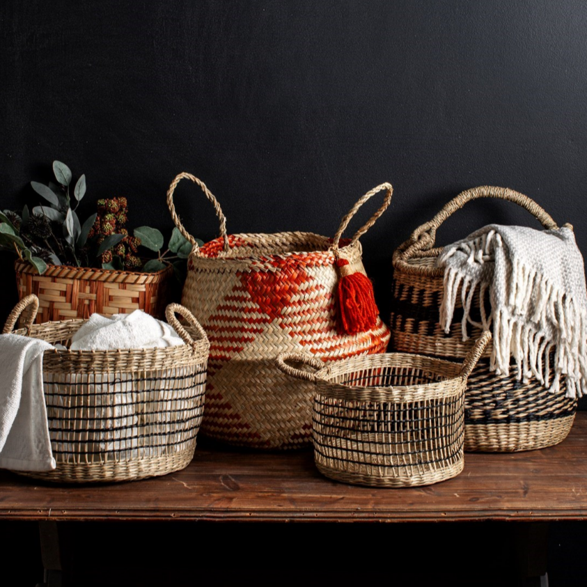 A variety of seagrass baskets merchandised with plants & towels inside them