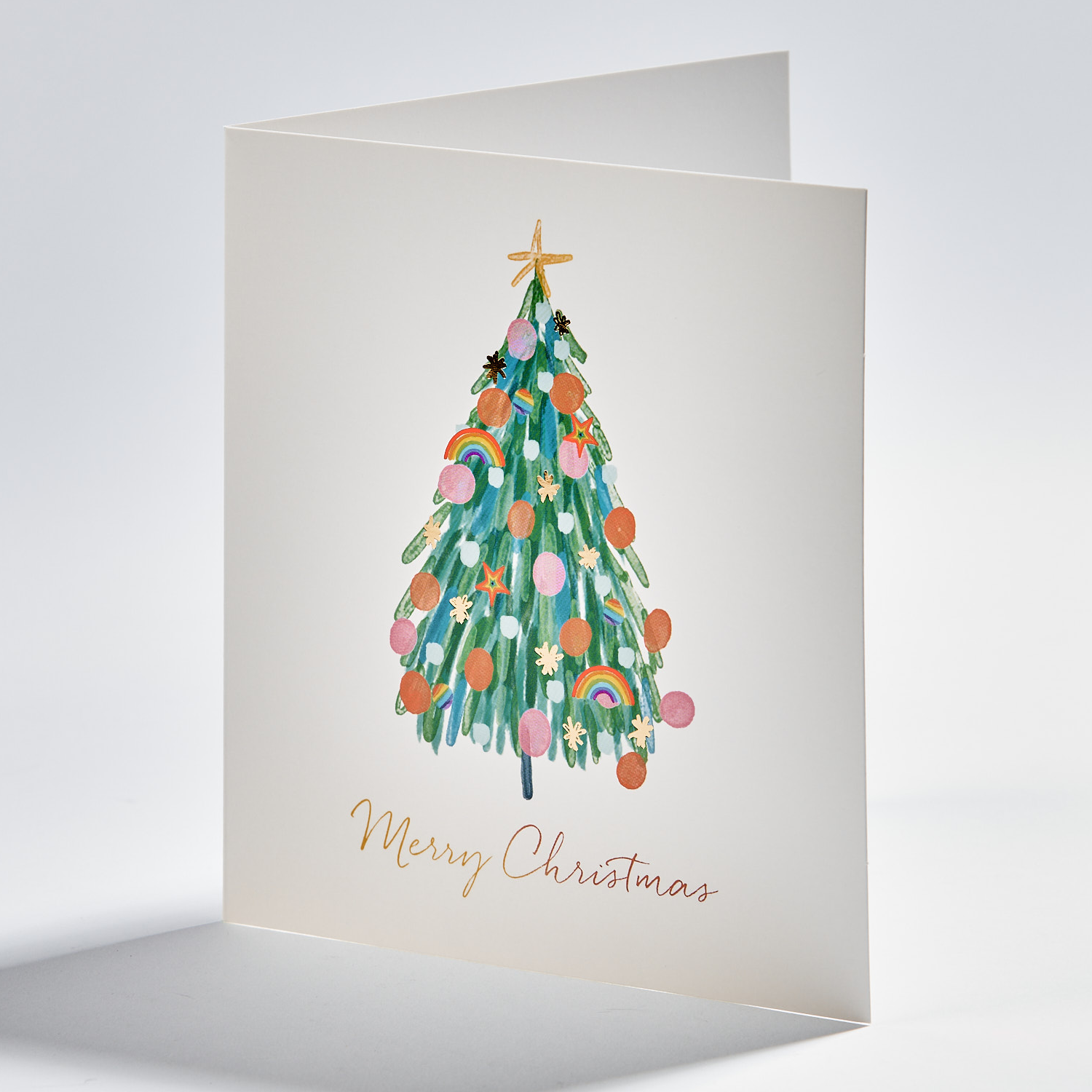 Standing christmas card depicting a christmas tree with rainbow pride decorations and text that reads merry christmas