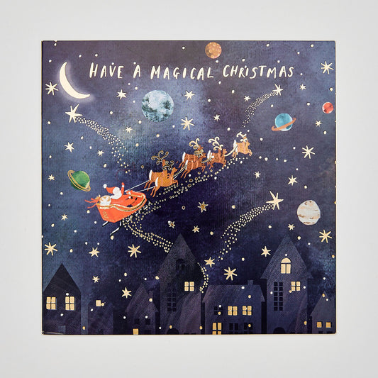 flat lay christmas card depicting santa riding his sleigh through a festive galaxy