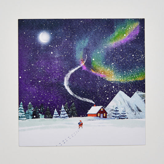 flat lay christmas card depicting santa under an aurora night