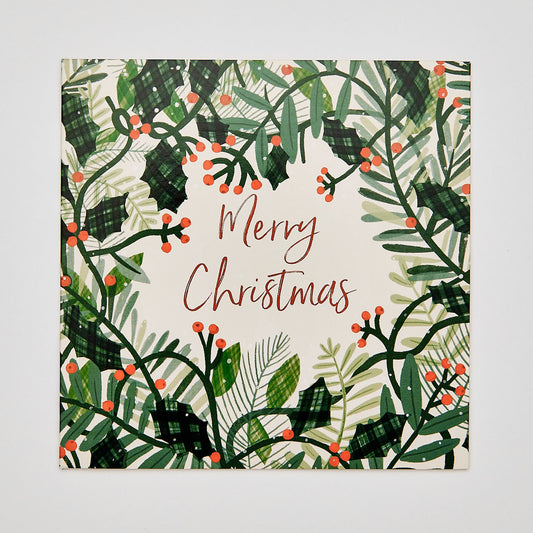 Flat lay of christmas card with festive holly message reads 'merry christmas'