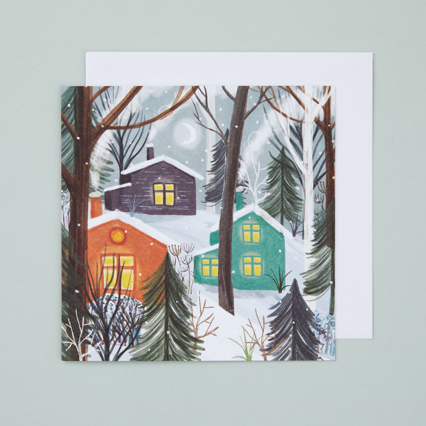 A square Christmas card with an illustration depicting colourful cabins in a snowy forest.