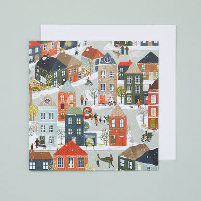 A square Christmas card with an illustration depicting busy festive city street scene.