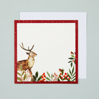 A square flat card with a red border and stag and holly illustrated in the corner. There's a blank section in the middle for your own message.