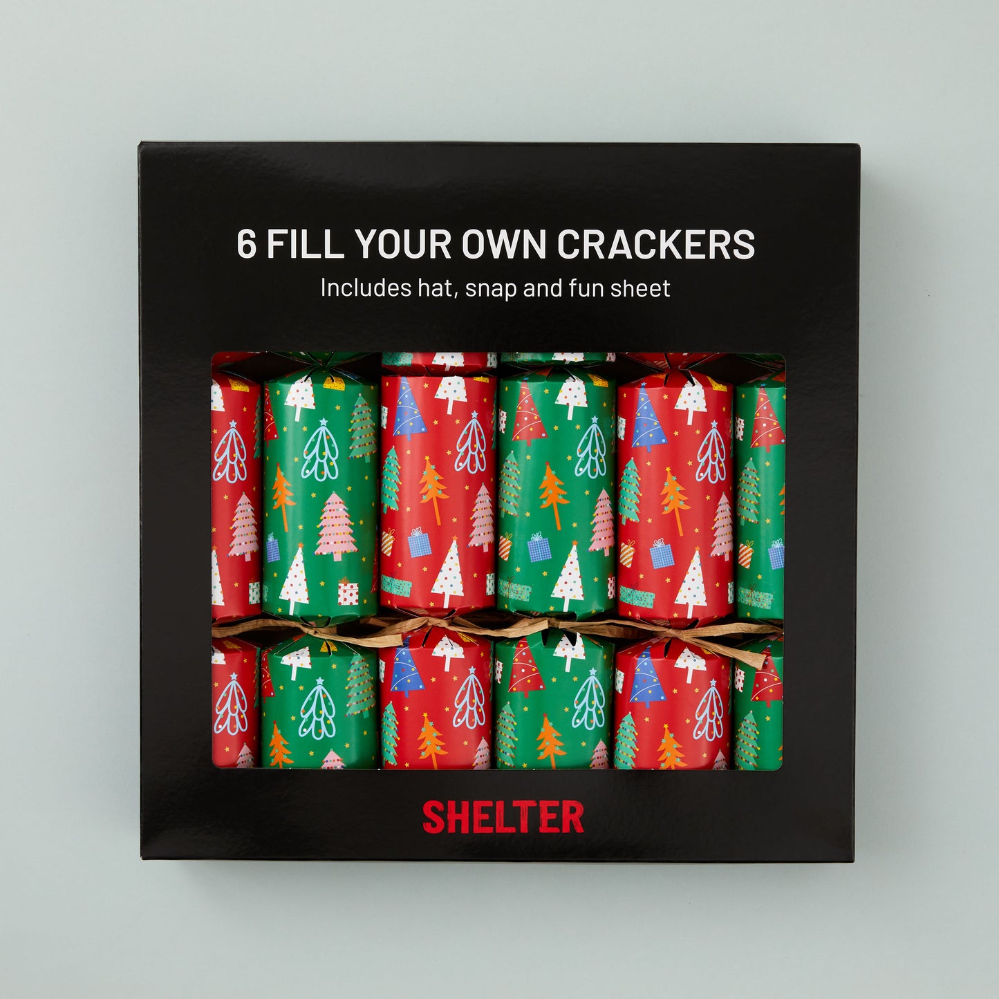 A box of 6 Christmas crackers with red and green Christmas tree design in a card Shelter branded box.