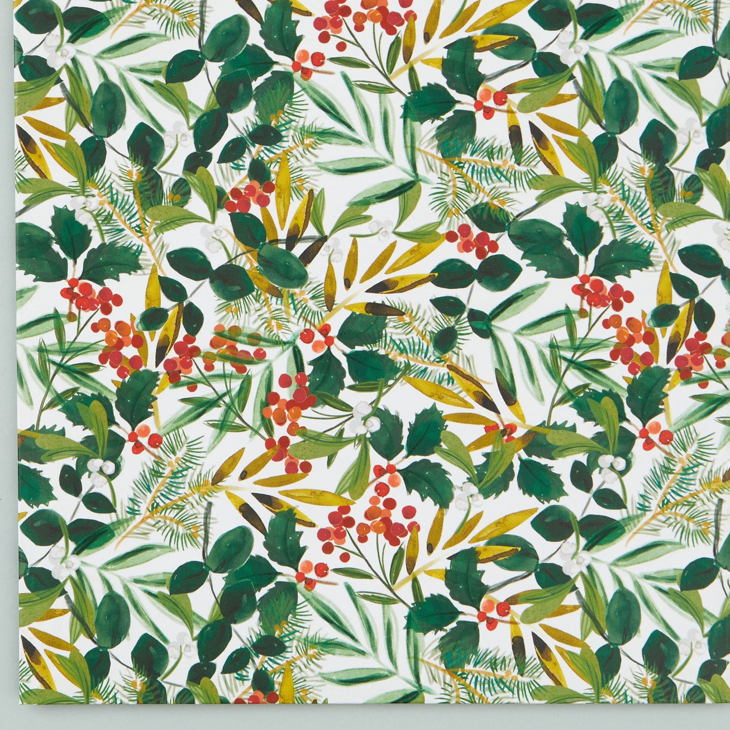 Close up of the foliage design with different green leaves and red berries.