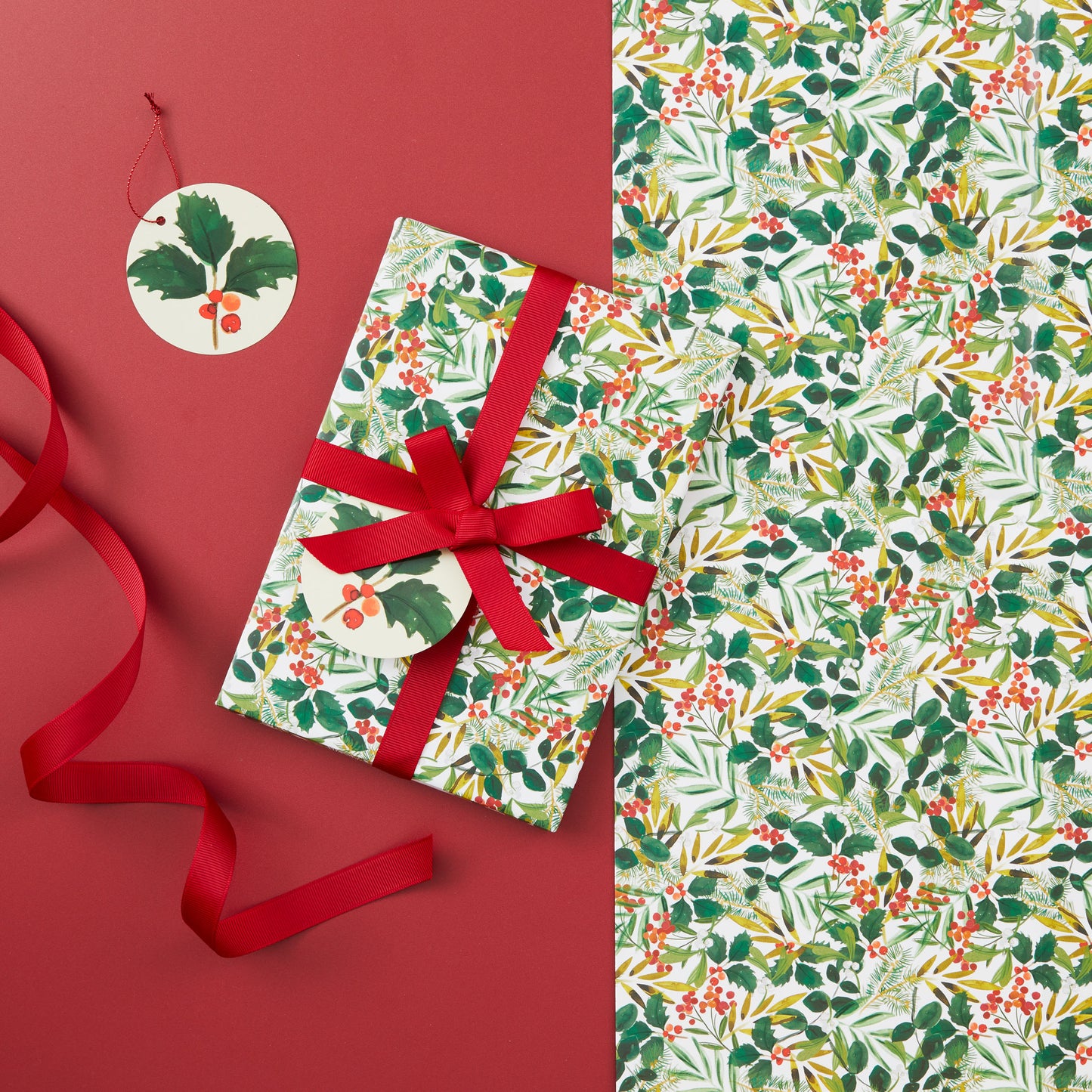 A present wrapped in foliage gift wrap and tied with a red ribbon.