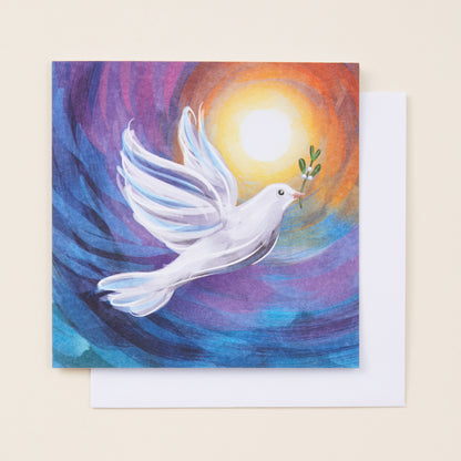 A square Christmas card with a stylised image of a dove at sunset on the front, sitting on a white envelope.