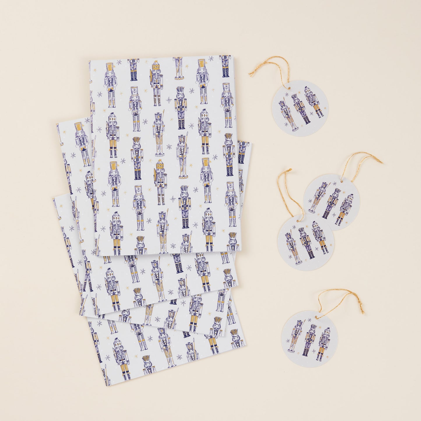 Set of four sheets of wrapping paper and tags with gold string. The design features a gold nutcracker pattern against a white background.