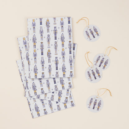 Set of four sheets of wrapping paper and tags with gold string. The design features a gold nutcracker pattern against a white background.