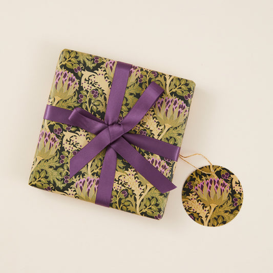 Gift wrapped in floral paper with a purple ribbon on a beige background