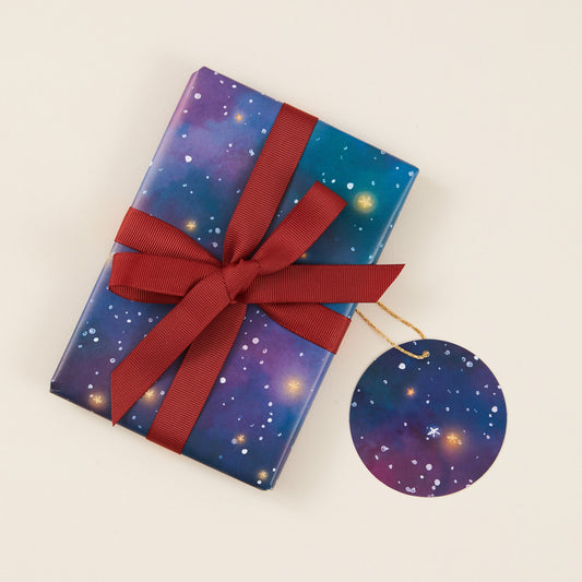 Gift box with starry design and red ribbon on a beige background
