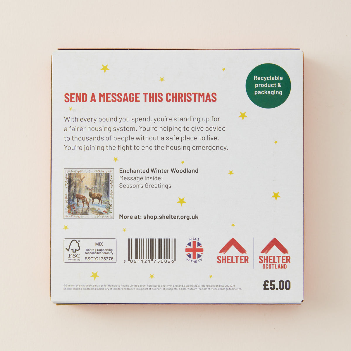The back of a white rectangular product box with red and black text, a small illustrated winter woodland scene, a barcode, and Shelter branding, photographed against a light beige background.