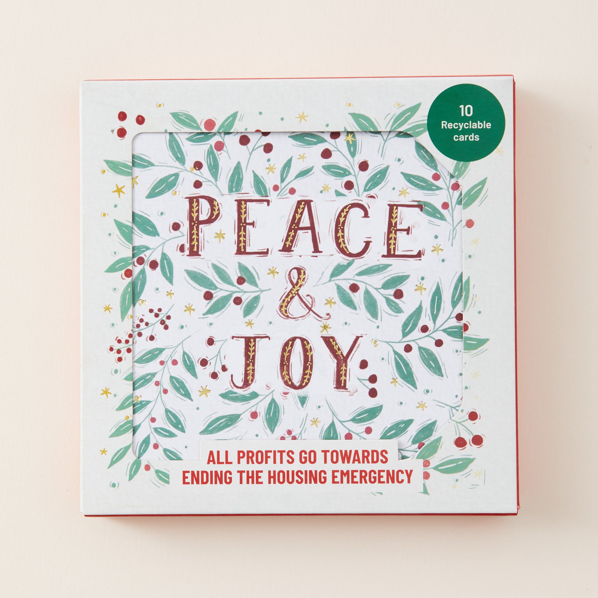 A square card deck box titled 'PEACE & JOY' with a white background, decorated with green leaves, red berries, and gold stars. A green circular sticker in the top right says '10 Recyclable Cards'.