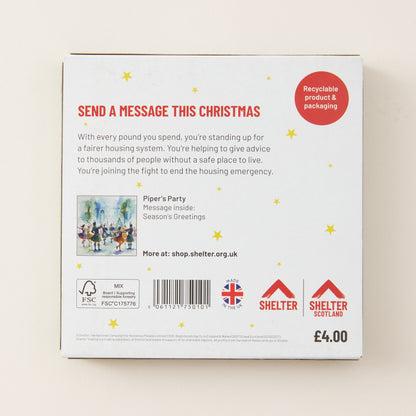 The back of a white cardboard box for a Christmas message service, featuring red and black text, a small illustration, and logos for Shelter and Birkwood Trust. The box is photographed on a light beige background.