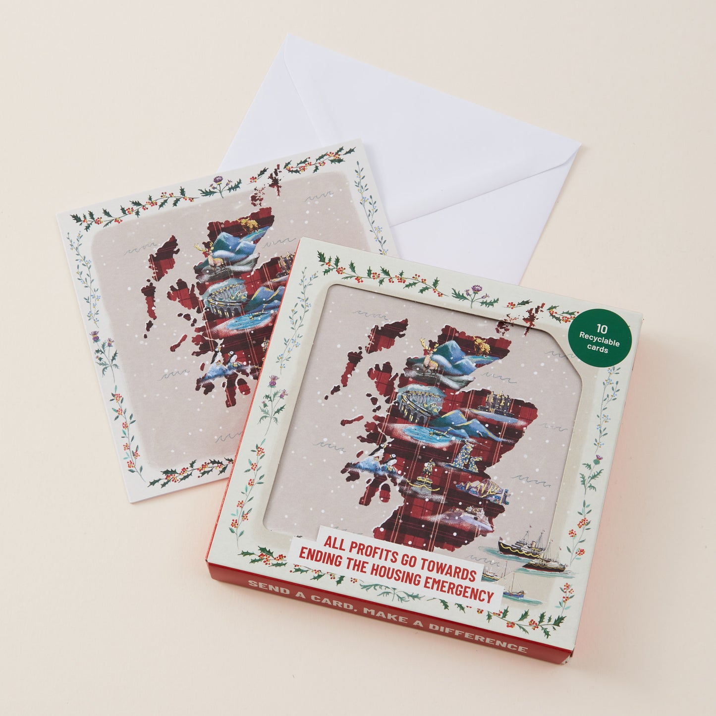 A square greeting card and matching envelope displayed on a light beige background. The front card is in a clear windowed box with a red base and floral border, showing a collage of people and housing-related imagery.