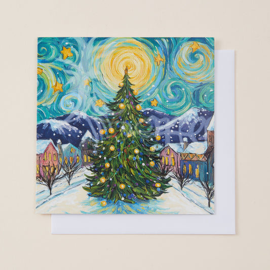 A square art print or card featuring a whimsical Christmas village scene in a swirling, Van Gogh-inspired style, with a decorated evergreen tree in the foreground, mountains, houses, and a bright yellow starry sky. A white envelope is partially visible behind it on a light beige background.