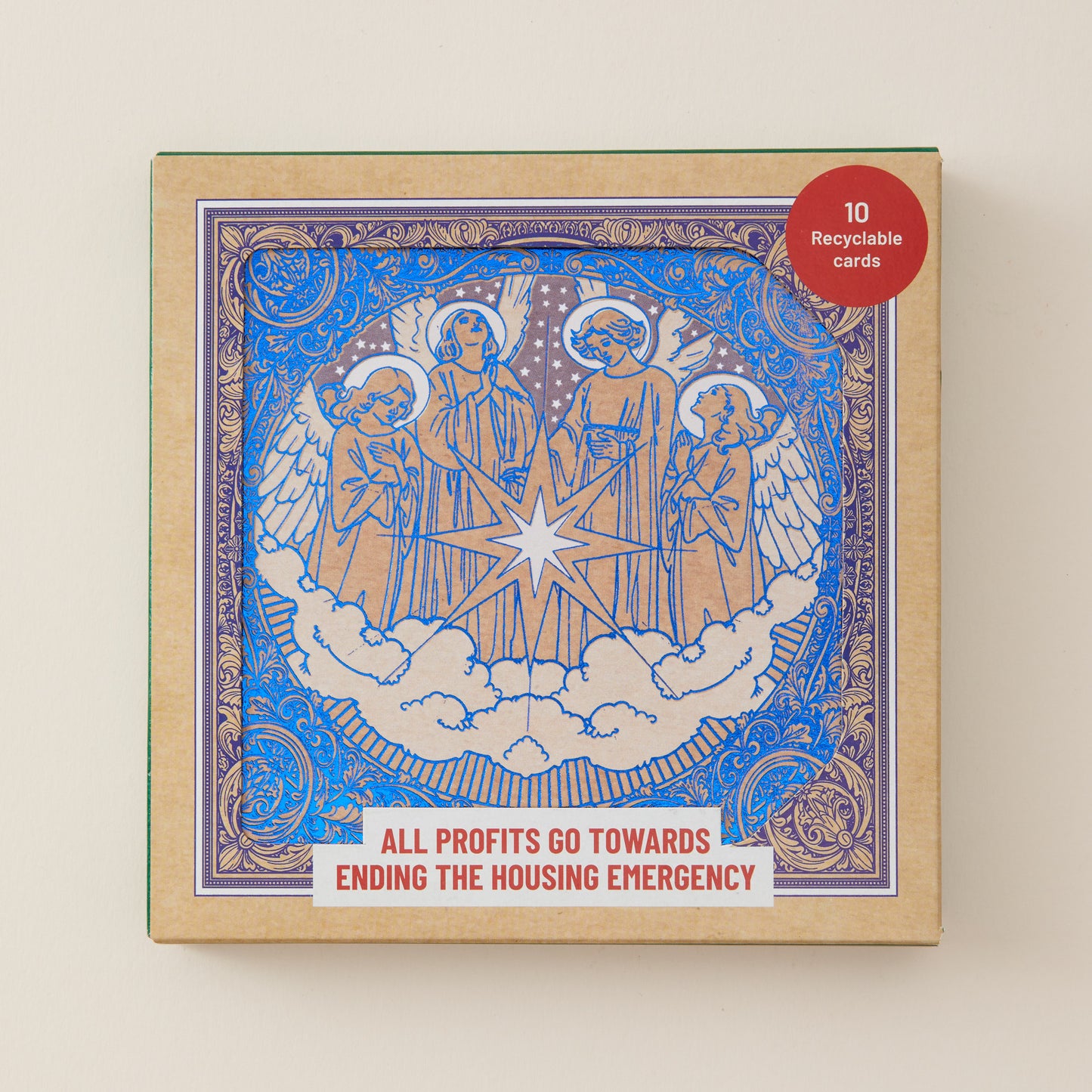 A square product box for a card deck featuring an illustrated angel scene in blue and gold with white clouds and a central star. The box has a red circular sticker reading '10 Recyclable cards' and a white banner at the bottom that says 'ALL PROFITS GO TOWARDS ENDING THE HOUSING EMERGENCY.