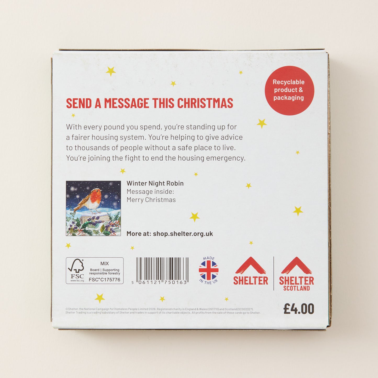 The back of a white Christmas-themed product box with red and black text, a small holiday illustration, a barcode, and Shelter branding on a light beige background.