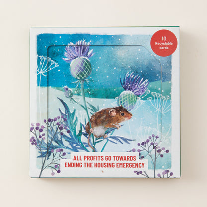 A square boxed card set with a whimsical illustrated cover showing a small brown mouse among purple flowers against a blue winter sky. A red circular badge in the top right says '10 Recyclable cards,' and the bottom text reads 'ALL PROFITS GO TOWARDS ENDING THE HOUSING EMERGENCY.