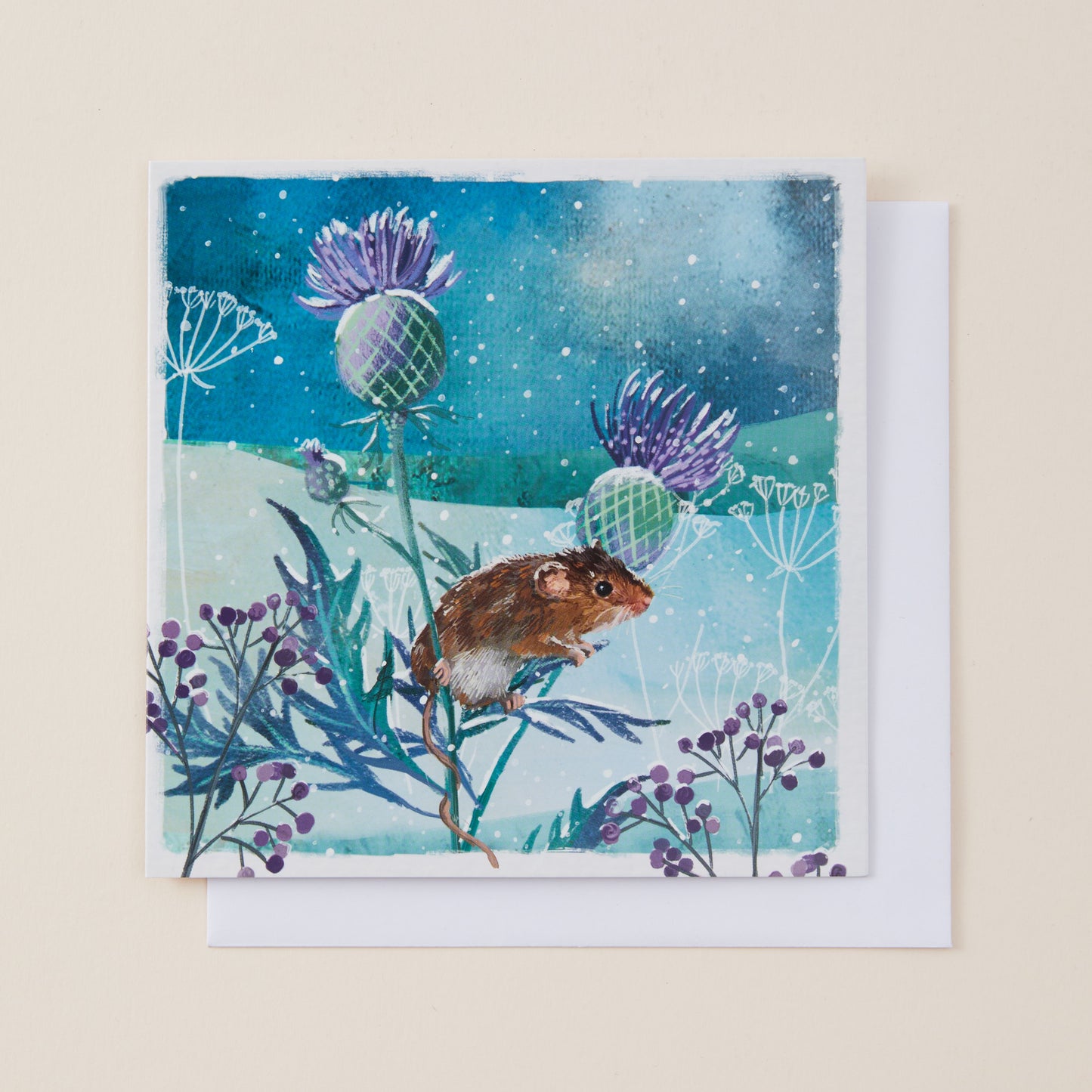 A square art print or card featuring a painted scene of a brown mouse among purple flowers and blue-green plants under a starry night sky, shown with a white envelope behind it on a light beige background.