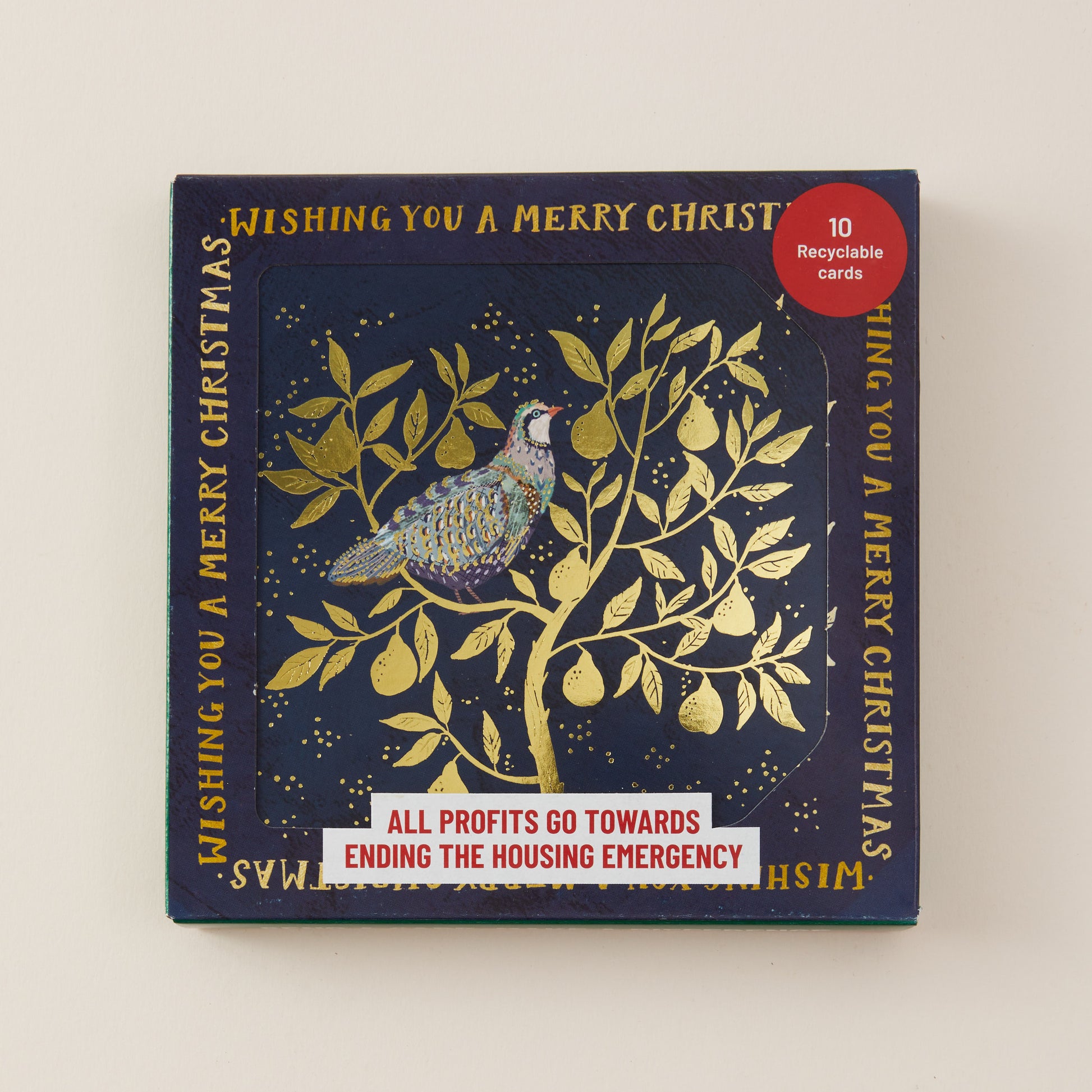 A square Christmas card set box with a navy blue background and gold foil illustration of a bird perched on a leafy tree. The box includes gold text reading 'Wishing you a merry Christmas' and a red circular badge that says '10 recyclable cards.