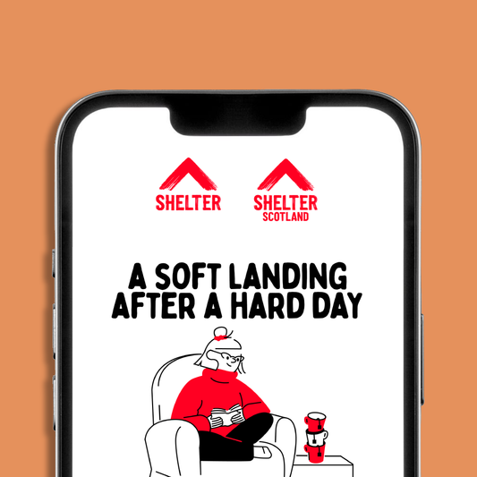 A smartphone mockup on an orange background displaying a Shelter and Shelter Scotland logo with an eCard design on it. The eCard has text 'A SOFT LANDING AFTER A HARD DAY' and an illustration of a person sitting in a chair.