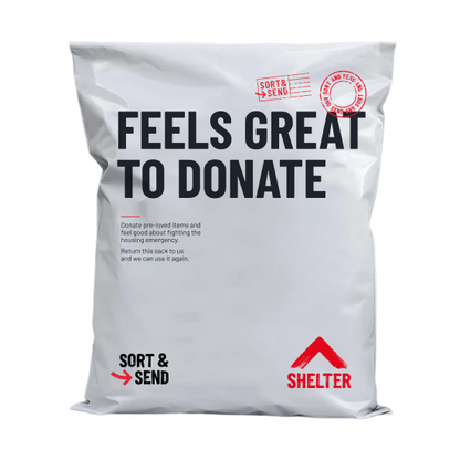 A white flat mailer bag with printed text reading 'FEELS GREAT TO DONATE' in large black letters, plus red and black 'SORT & SEND' and 'SHELTER' branding, photographed on a plain white background.