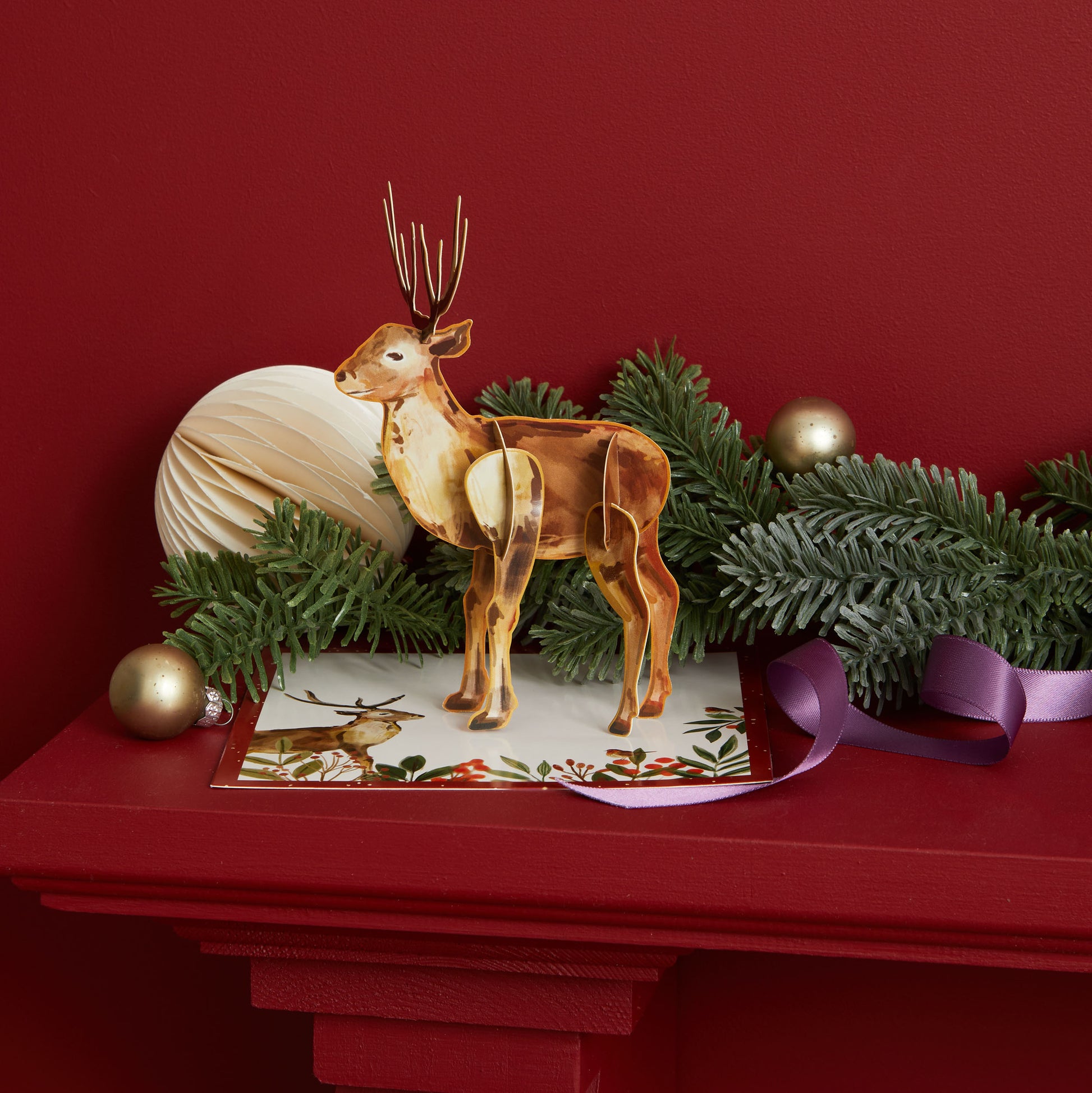 Stag ornament fully assembled shown on a red mantlepiece with festive decorations