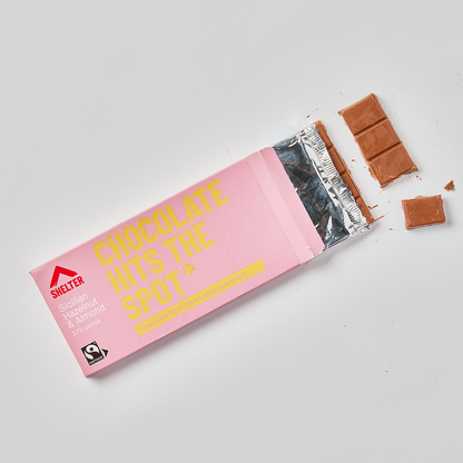 Pink wrapper chocolate bar with yellow writing saying "chocolate hits the spot"