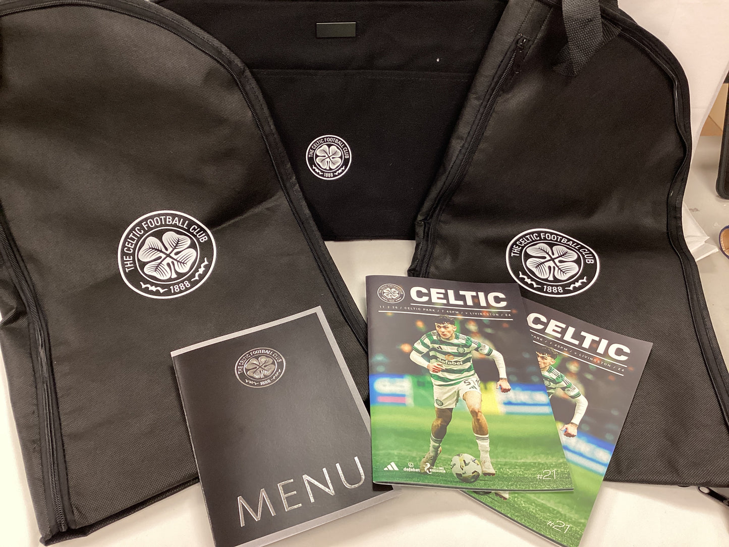 Celtic Hospitality Gifts from Celtic FC vs Livingston FC Match 11/02/2026. 2x Programmes, 2x Suit Carriers, 1x Laptop Bag, 1x Menu