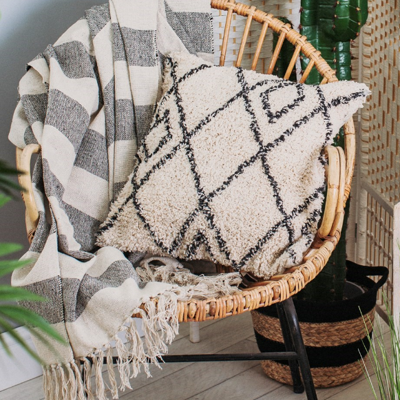 Berber cushion displayed on a wicker chair with blankets