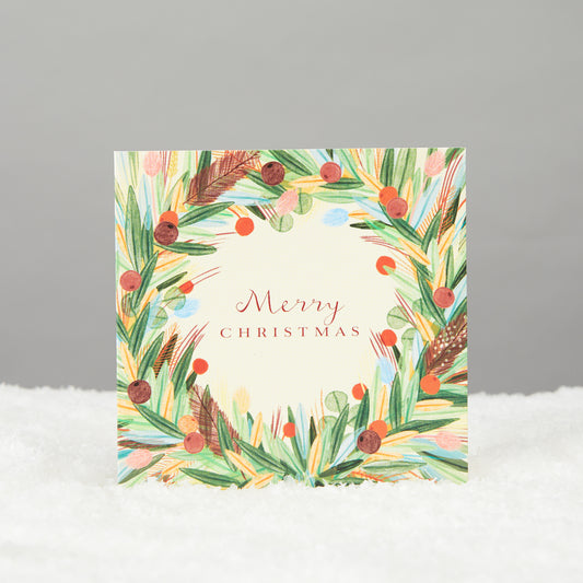 Square card reads Merry Christmas with foliage wreath detailing