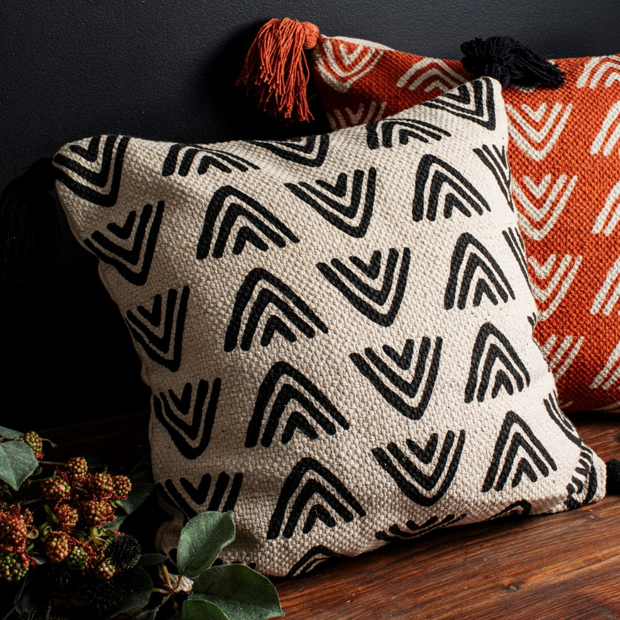 lifestyle shot of the black & white cushion we have available for sale, shown with another colourway of orange. 